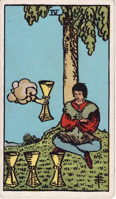 A young man sits beneath a tree with folded arms, facing three cups while a hand from a cloud offers him a fourth.