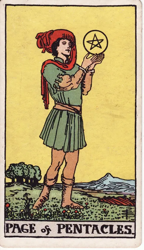 A young page in green clothing and red headwear studies a golden pentacle in a meadow, with trees, cultivated land and blue mountains behind him.