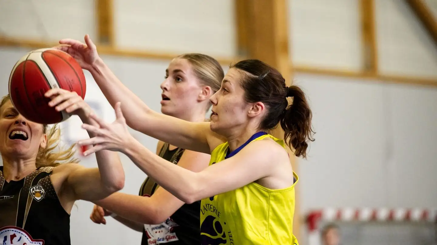 Basketball players compete for the ball.