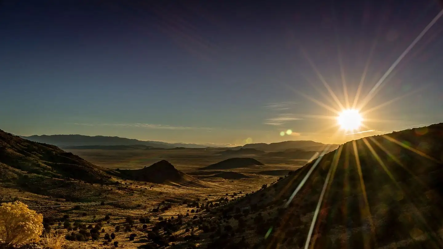 Sunrise casting golden rays across a mountain landscape