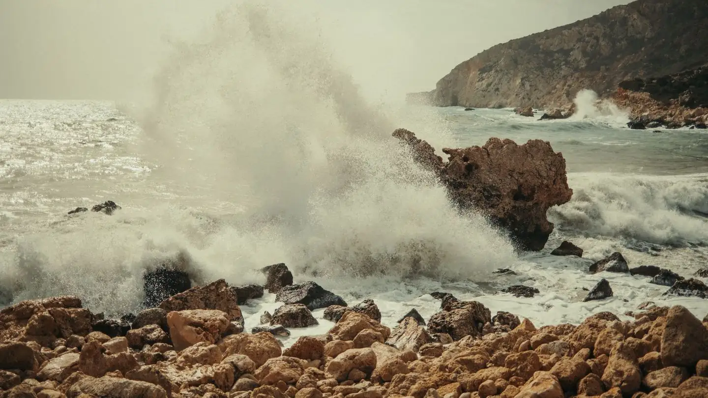 Ocean waves break against a rocky shore.