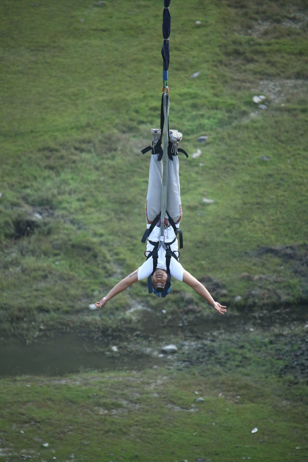 A man hanging upside down from a bungee cord